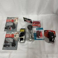 Full view of assorted bike accessories including mirrors, horn, lights, and reflectors arranged on white cloth background.