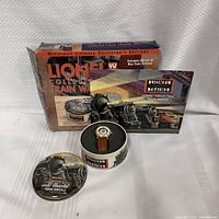Full set of Lionel collectible train watch including original packaging box, metal tin, watch inside the tin, and instruction booklet.