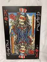 Full front view of the Grateful Dead wooden poster showing the King of playing cards skeleton character with swords and roses.