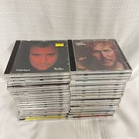 Stack of 40 assorted CDs showing front covers of Phil Collins and Gordon Lightfoot albums on top