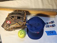 Photo showing the full lot: Barnett glove, Blue Jays cap, yellow Worth softball, vintage baseball bat lying horizontally, and two Blue Jays barrettes.