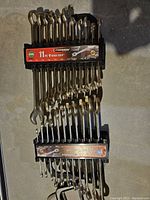 Photo showing two rows of Thompson combination wrenches in metric and SAE, 11 pieces each, with chrome finish.