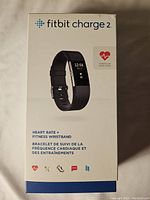 Front of Fitbit Charge 2 original white box showing product image, Fitbit logo, and heart rate fitness wristband text in multiple languages.