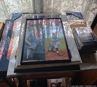 Framed signed plaque with two baseball player pictures and autographs stacked on table