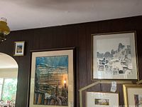 Room wall displaying three framed original art pictures by Jerusalem artist, one small and two larger works.
