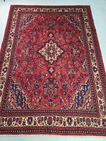 Full view of red field Hamedan rug with central medallion and borders