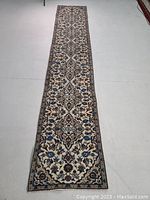 Full view of runner rug laid on floor showing overall design and condition