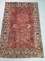 Full top view of the Persian rug showing its overall pattern and colors on floor.