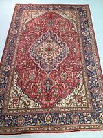 Full view of hand knotted wool rug showing central medallion, border design and overall condition