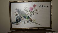Full view of the framed Chinese silk embroidered tapestry showing the bird, flowers and calligraphy.