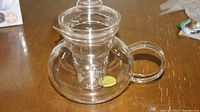 Clear Primula glass teapot with visible cylindrical infuser inside and dome lid, showing overall condition and design.