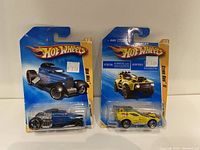 Two Hot Wheels cars in original packaging: Mid Mill and Sting Rod '11 from Premiere series.
