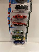 Front view of stacked Hot Wheels Retro Racers vehicles in original packaging showing various models including motorcycle and cars of different colors.