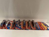 Front view of 8 Hot Wheels cars in sealed original packaging showing the front and side profiles.