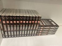 Front view of Berserk manga volumes 2 through 12 and volume 14 showing spines aligned on a shelf.