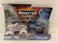 Front view of sealed Hot Wheels Monster Jam Gears Galaxies pack featuring Blue Thunder and Grave Digger trucks.