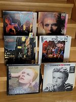 Front covers of six David Bowie vinyl LP albums arranged in two rows on wooden stairs.