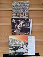 Photo showing three vinyl record covers: Physical Graffiti (top), Houses of the Holy (middle), Led Zeppelin IV (bottom).