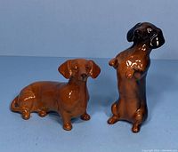 Both Beswick England dachshund dog figurines displayed together on blue background, showing size and condition.