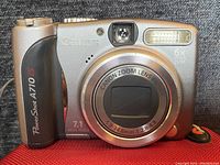 Front view of Canon PowerShot A710 IS showing lens, flash, viewfinder, and branding.