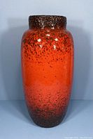 Front view of large vintage West German pottery vase in orange and dark brown fat lava glaze.