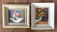 Pair of framed vintage oil paintings featuring floral still lifes signed by Cerno, showing the full lot.