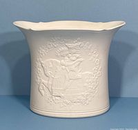 Front view of the white bisque vase showing full embossed design and scalloped rim.