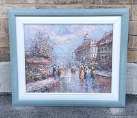 Full view of the framed painting showing an impressionistic European street scene with pedestrians, buildings, and wet pavement.
