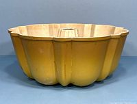 Side view of the vintage Nordic Ware mini Bundt pan showing gold exterior finish and scalloped edges.