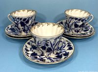 Three teacups arranged with matching saucers, showing bluebell floral pattern with gold embellishments