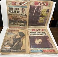 Four Toronto Sun newspapers from 1980s with John Lennon-related headlines in plastic sleeves.