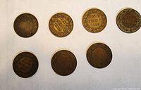 Seven Canadian one cent coins showing obverse and reverse sides with dates 1900, 1909, 1910, 1913, 1916, 1917, 1919.