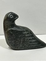 Side view of the green soapstone bird carving showing shape, color, and stone texture.