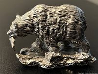 Close-up side view showing detailed textured fur and fish in bear's mouth