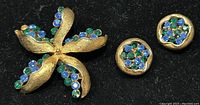 Front view showing gold-tone starfish brooch with blue and green rhinestones and matching earrings