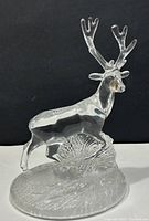 Front and side view of clear lead crystal deer stag figurine on textured base.