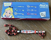 Photo showing the collectible key and its open box packaging with illustration of Alice and the six key designs shown.
