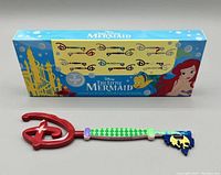 Two Disney The Little Mermaid Mystery Keys in front of the original box showing series artwork.