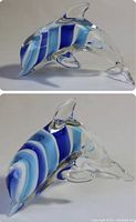 Top and side views of hand blown glass dolphin figurine with blue and white stripes and clear glass fins.