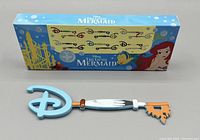 Photo of the Scuttle mystery key with the original box showing the key design and packaging.