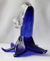 Single blue and clear glass decorative flower sculpture with an elongated blue central petal and clear petals extending outward with ribbed texture.