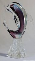 View of the full Murano glass dolphin figurine showing multicolor glass and textured base.