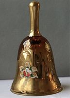 Photo of a gold tone Murano glass bell with hand-painted floral design and a smooth shiny finish. The bell shows signs of wear.