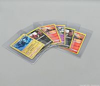 Six non-sports trading cards in protective plastic sleeves, depicting various fantasy or game-themed characters.