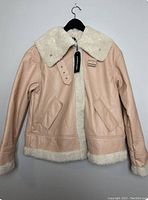 Front view of the pink suede jacket with off-white faux shearling collar and lining, showing the zipper and snap closure with original tags attached.