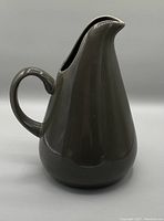 Side view of the charcoal grey ceramic pitcher by Russel Wright, showing its shape and handle