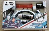 Front view of the boxed Star Wars Lightsaber Forge set by Hasbro and Disney, new in sealed packaging for ages 4+. Shows product name, characters on box art, and forge components visible through window.