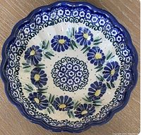 Top view of a single Unikat Polish pottery candy dish showing floral hand painted design and scalloped edges.
