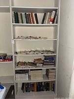 Shelf with a large collection of books including cooking magazines, Time Life cookbooks, and a mix of fiction and political books.
