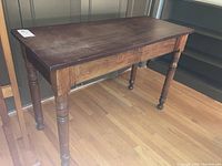 Full side view of vintage wooden sofa table showing condition and turned legs.